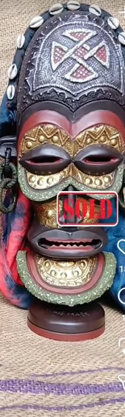 Tall mask with a cowrie-lined crest, brass relief and dyed cloth, marked sold