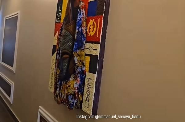 Carved mask on a colourful patterned fabric panel hanging in a corridor